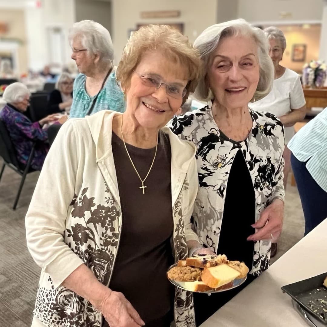 Two Warm Beach residents smiling over a plate of food
